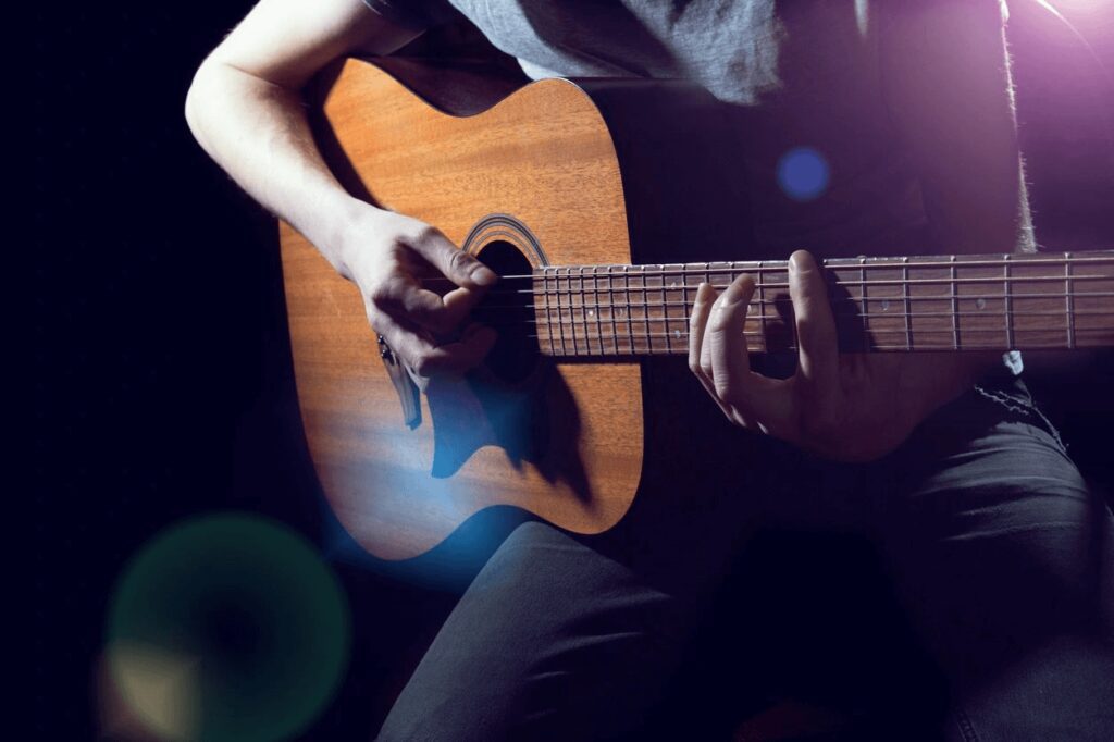 A man playing a guitar in brown color